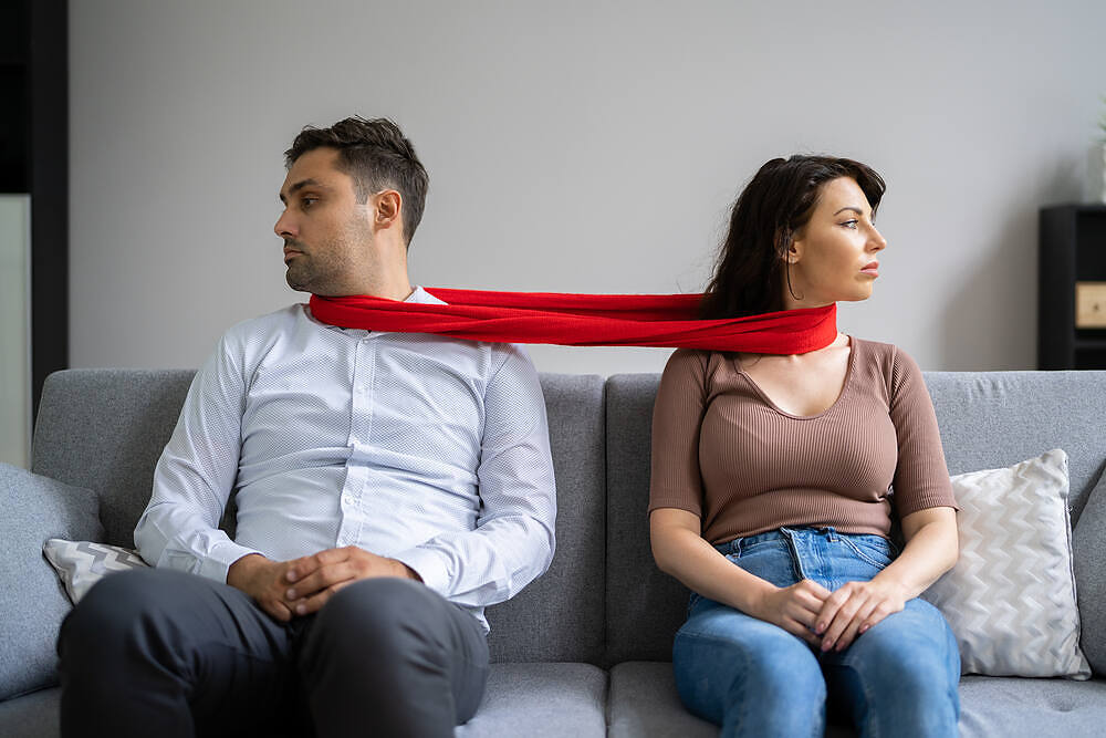 Couple sitting apart on couch, connected by red scarf, symbolizing relationship tension due to addiction|Young woman gesturing to young man, gesturing to young man holding alcohol bottle in car in driver's seat, illustrating risky behavior and peer pressure in teen alcohol use|A couple sitting on a couch in a therapy session, with a female counselor facing them, depicting relationship support during addiction treatment