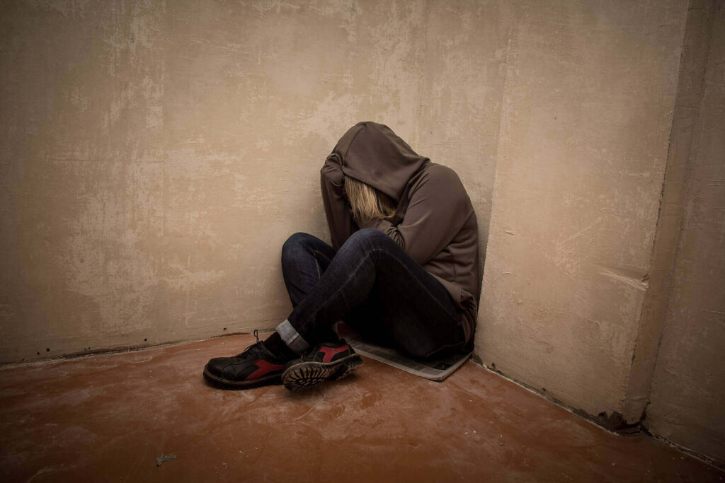 Person in hoodie sitting alone in corner, depicting depression and isolation often associated with addiction|Close-up image of drug paraphernalia including a syringe, spoon, and an outstretched arm, illustrating the harsh reality of heroin addiction|Infographic showing statistics on heroin users entering treatment in Europe, including gender, route of administration, source of referral, and frequency of use|Side-by-side comparison of a woman's appearance during peak heroin use and after 3
