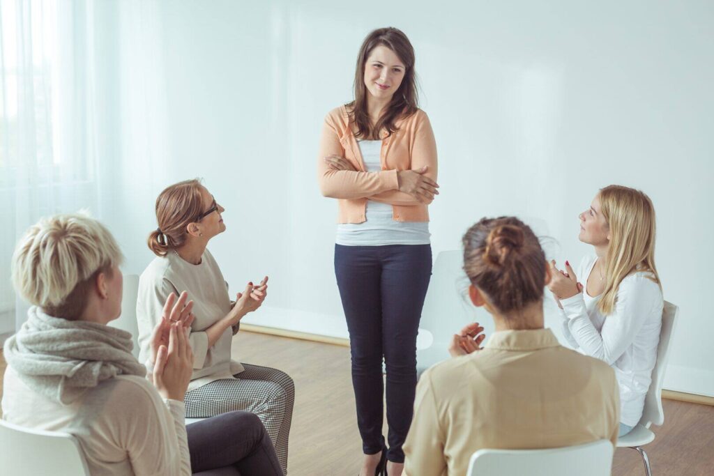 Female counselor leading a group therapy session with four participants in a bright, supportive environment|Illustration of multiple support groups with figures gathered around signs reading 'Support Group', representing the community aspect of 12 Step Programmes|Diverse group of people sitting in a circle during a therapy session, including men and women of various ethnicities, engaging in discussion in a bright, modern setting|Infographic comparing Subutex and Suboxone, detailing what they are, what they do, benefits, and cons of each opioid detox medication, with Detox Plus UK logo