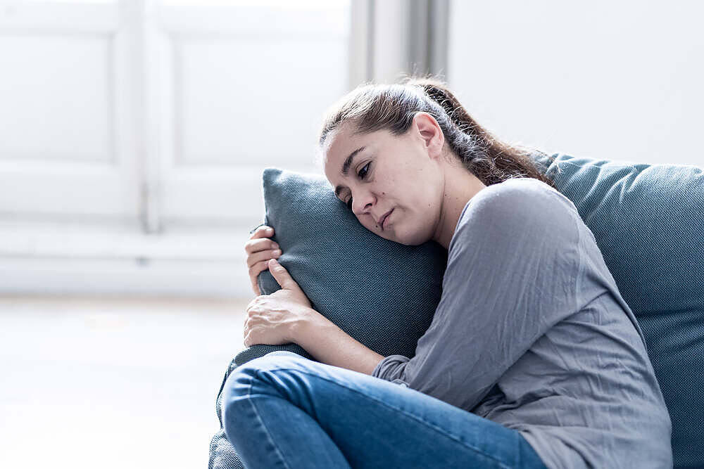 Distressed woman hugging pillow on couch, exhibiting signs of withdrawal during addiction recovery process|Close-up of drug paraphernalia including a syringe, white powder, plastic bag, lighter, and aluminum foil on a dark wooden surface|Bar graph showing the increasing trend of deaths from drug poisoning by heroin and morphine in England and Wales from 1993 to 2017, peaking at 1,209 deaths in 2016|Person in grey hoodie sitting curled up against a wall, head down and arms wrapped around knees, with drug paraphernalia on the floor, depicting the isolation and difficulties of substance abuse and withdrawal|Woman experiencing emotional distress during heroin withdrawal, receiving counseling from a supportive therapist in a calm, clinical setting