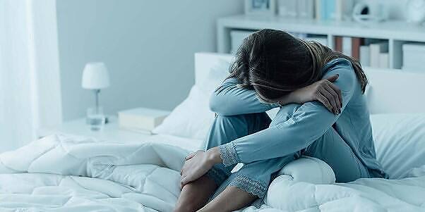 Distressed woman sitting on bed, hugging knees, head down, depicting insomnia and potential zopiclone addiction side effects|Woman in blue pajamas sitting on bed, head down and hugging knees, depicting depression and insomnia often associated with substance abuse and withdrawal|African American woman with curly hair lying awake in bed at night, looking distressed, with an alarm clock showing 3:00 in the foreground, illustrating insomnia potentially related to addiction or recovery|Box and blister pack of Zerenix (Zopiclone 7.5mg) tablets, a prescription sleep medication, showing 20 coated tablets|Infographic on Zopiclone use, addiction, and withdrawal symptoms. Includes information on its purpose, how it works, addiction risks, withdrawal symptoms, and treatment options.